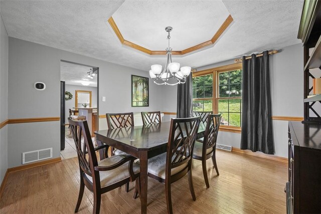 3004 Woodfield Dr, Hopewell Twp Bea, PA 15001 - dining room featuring a chandelier, light wood finished floors, a textured ceiling, and a raised ceiling