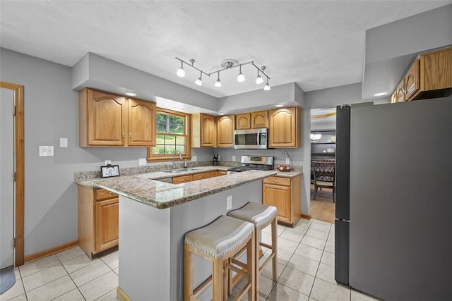3004 Woodfield Dr, Hopewell Twp Bea, PA 15001 - kitchen featuring appliances with stainless steel finishes, light tile patterned floors, a kitchen bar, light stone countertops, and a textured ceiling