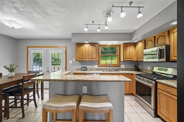 3004 Woodfield Dr, Hopewell Twp Bea, PA 15001 - kitchen with appliances with stainless steel finishes, a kitchen bar, light tile patterned flooring, and a kitchen island