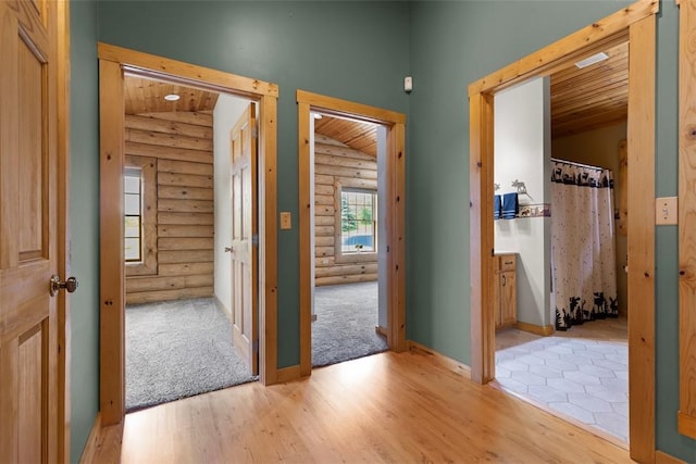 1155 Sarver Rd, South Buffalo Twp, PA 16055 - hallway with log walls, wood ceiling, and light wood-style flooring
