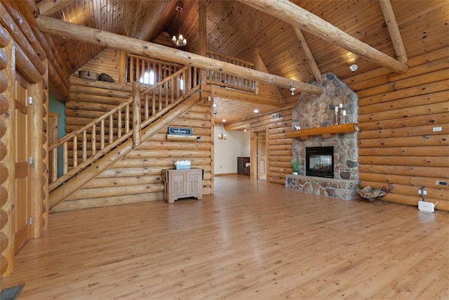 1155 Sarver Rd, South Buffalo Twp, PA 16055 - unfurnished living room featuring high vaulted ceiling, log walls, a wood ceiling with exposed beams, wood finished floors, and a fireplace