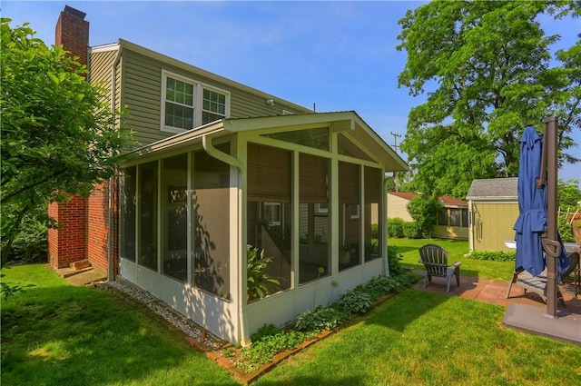 217 Baintree Rd, Moon/Crescent Twp, PA 15108 - view of side of property with a sunroom, a chimney, a patio, and a lawn