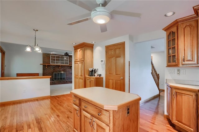 217 Baintree Rd, Moon/Crescent Twp, PA 15108 - kitchen featuring a ceiling fan, light wood-style flooring, a fireplace, and light countertops