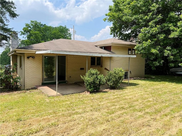 131 Monica Dr, Hempfield Twp Wml, PA 15601 - back of property featuring brick siding, a patio area, a yard, and a chimney