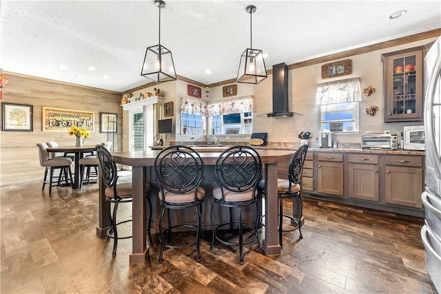 140 Jocelynn Ln, Smithfield, PA 15478 - kitchen featuring wall chimney range hood, a kitchen breakfast bar, glass insert cabinets, a textured ceiling, and ornamental molding