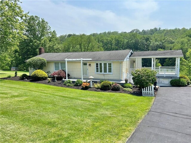 71 Armstrong Dr, Canton Twp, PA 15301 - ranch-style home with a front yard, a chimney, covered porch, and a wooded view