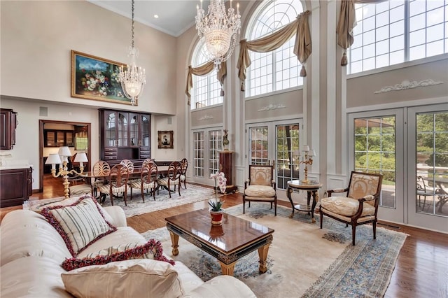 7023 Fair Oaks Dr, Export, PA 15632 - living area with a high ceiling, a chandelier, wood finished floors, french doors, and crown molding