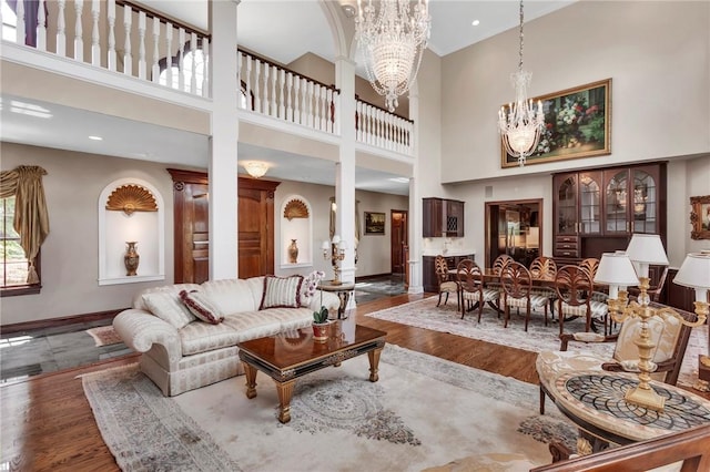 7023 Fair Oaks Dr, Export, PA 15632 - living room featuring a chandelier, a towering ceiling, wood finished floors, and decorative columns