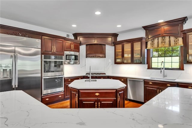 7023 Fair Oaks Dr, Export, PA 15632 - kitchen featuring appliances with stainless steel finishes, recessed lighting, light stone countertops, glass insert cabinets, and light wood-style floors