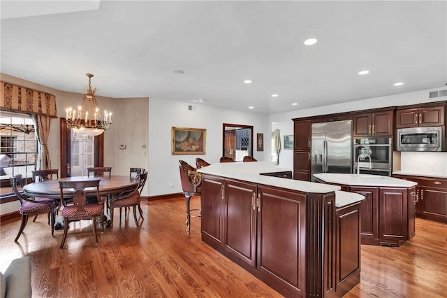 7023 Fair Oaks Dr, Export, PA 15632 - kitchen with built in appliances, a kitchen island, a chandelier, light wood-style flooring, and recessed lighting