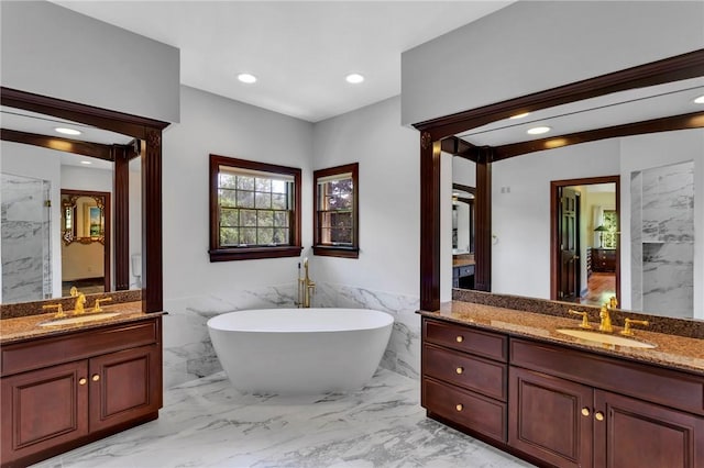 7023 Fair Oaks Dr, Export, PA 15632 - full bath featuring tile walls, marble finish flooring, two vanities, a soaking tub, and a wainscoted wall