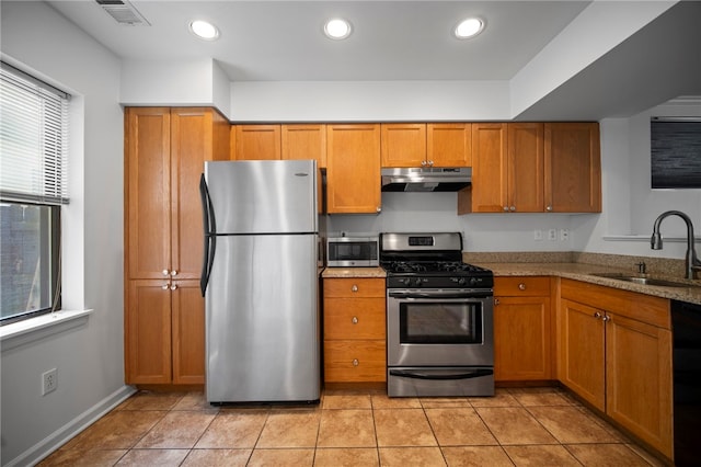 47 S 16th St, South Side, PA 15203 - kitchen with appliances with stainless steel finishes, under cabinet range hood, brown cabinetry, light stone countertops, and light tile patterned floors