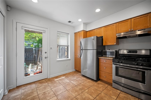 47 S 16th St, South Side, PA 15203 - kitchen with appliances with stainless steel finishes, under cabinet range hood, brown cabinets, recessed lighting, and light tile patterned floors