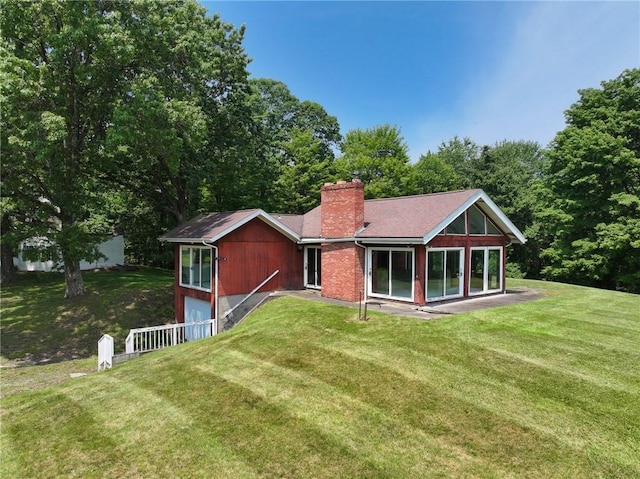 117 Stoneys Ln, Lehigh Twp, PA 16063 - back of property with a chimney, a lawn, and an attached garage