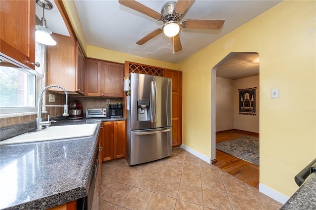 3037 Churchview, Baldwin Boro, PA 15227 - kitchen with stainless steel refrigerator with ice dispenser, dark countertops, arched walkways, brown cabinets, and ceiling fan