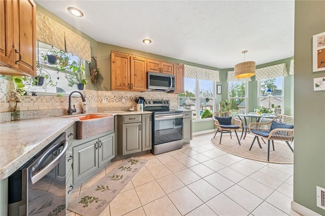74 Quail Run, Unity Twp, PA 15601 - kitchen featuring appliances with stainless steel finishes, light countertops, tasteful backsplash, light tile patterned floors, and hanging light fixtures
