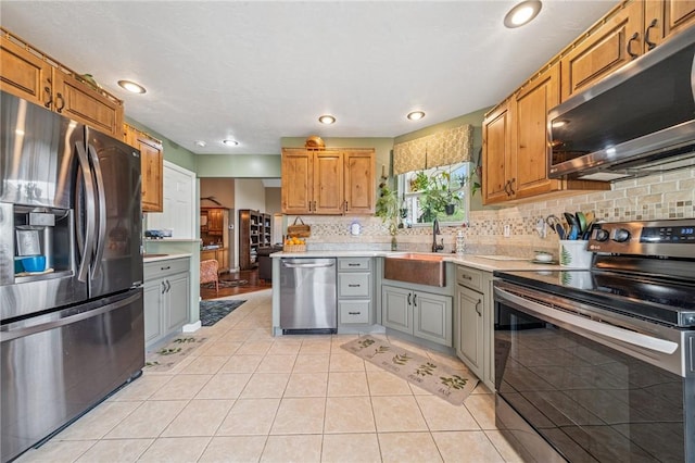 74 Quail Run, Unity Twp, PA 15601 - kitchen with stainless steel appliances, light countertops, decorative backsplash, light tile patterned floors, and gray cabinetry
