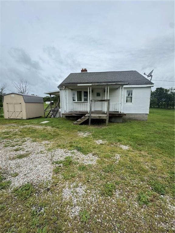 2193 Springhill Furnace Rd, Springhill Twp, PA 15478 - rear view of house with a storage unit, a lawn, a chimney, and covered porch