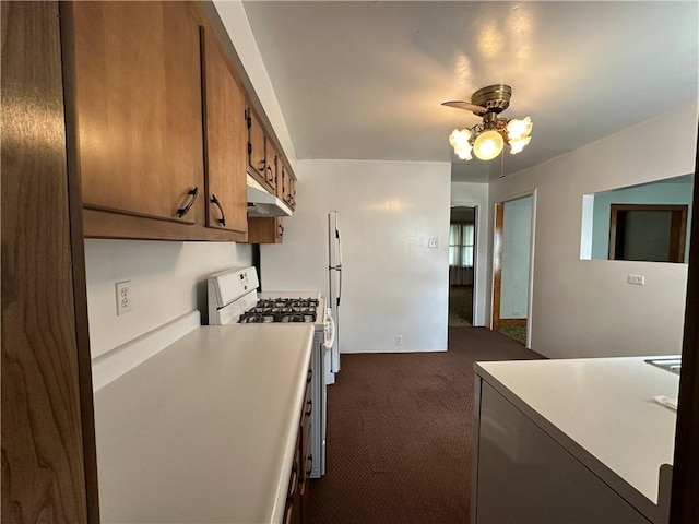 11637 State Route 85, Rayburn Twp, PA 16201 - kitchen with white range with gas stovetop, a ceiling fan, dark colored carpet, brown cabinetry, and under cabinet range hood