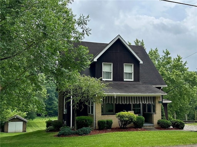11637 State Route 85, Rayburn Twp, PA 16201 - view of front of house featuring a front yard, a storage unit, brick siding, and a shingled roof