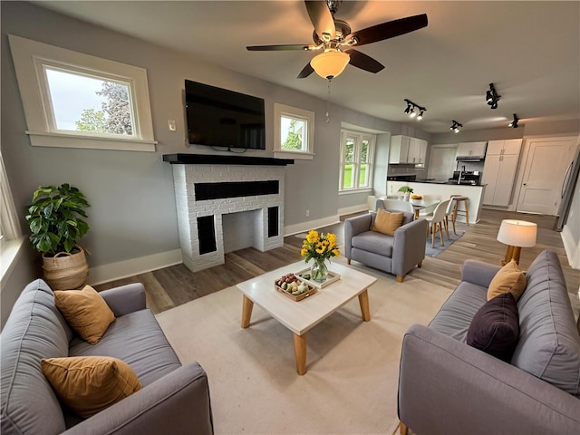 4352 Ellwood Rd, Wayne Twp Law, PA 16101 - living room with light wood-style floors, ceiling fan, a brick fireplace, and rail lighting
