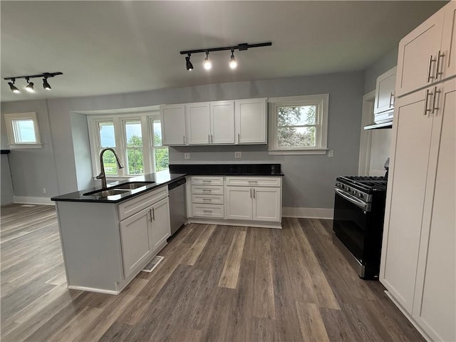 4352 Ellwood Rd, Wayne Twp Law, PA 16101 - kitchen with rail lighting, gas range oven, dishwasher, a peninsula, and white cabinets