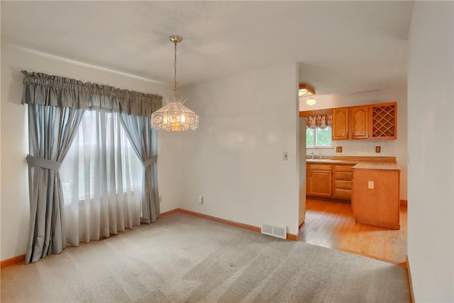 135 Jarod Dr, Moon/Crescent Twp, PA 15108 - unfurnished dining area with a chandelier, light carpet, and light wood-style flooring