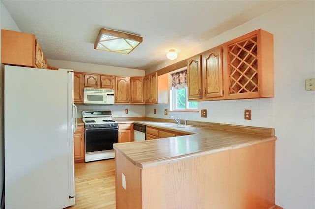 135 Jarod Dr, Moon/Crescent Twp, PA 15108 - kitchen with white appliances, a peninsula, light countertops, light wood-style flooring, and decorative backsplash