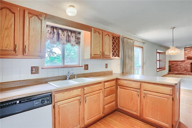 135 Jarod Dr, Moon/Crescent Twp, PA 15108 - kitchen with white dishwasher, light countertops, tasteful backsplash, a peninsula, and decorative light fixtures
