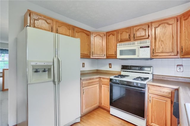 135 Jarod Dr, Moon/Crescent Twp, PA 15108 - kitchen with white appliances, light countertops, light wood-type flooring, and decorative backsplash