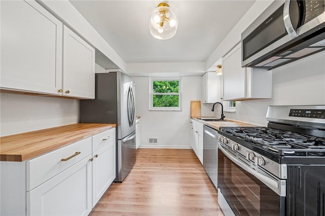 4154 Steiger St, Castle Shannon, PA 15234 - kitchen featuring stainless steel appliances, light wood-style flooring, butcher block counters, and white cabinetry