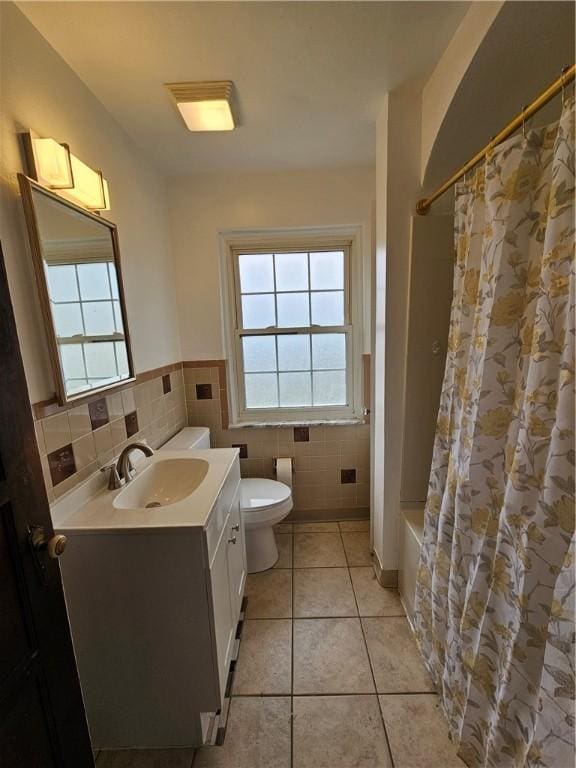 619 Ridge Ave, New Kensington, PA 15068 - bathroom featuring vanity, tile patterned flooring, healthy amount of natural light, shower / bath combo with shower curtain, and tile walls