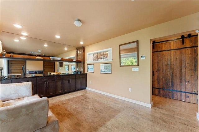 548 Penn St, Verona, PA 15147 - kitchen featuring a barn door, dark brown cabinets, recessed lighting, open floor plan, and dark stone counters