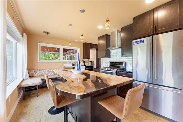 548 Penn St, Verona, PA 15147 - kitchen with appliances with stainless steel finishes, wall chimney exhaust hood, dark brown cabinetry, and a breakfast bar