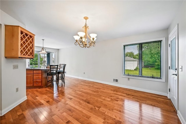 11504 N Shore Dr, Conneaut Lake Cra, PA 16316 - kitchen with light wood-type flooring, brown cabinets, a chandelier, and pendant lighting