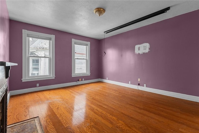 330 Jefferson Ave, City Of Washington, PA 15301 - spare room with light wood-type flooring, a textured ceiling, and a fireplace