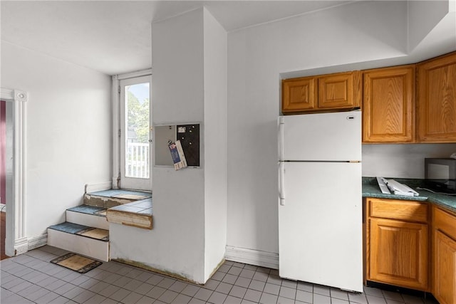 330 Jefferson Ave, City Of Washington, PA 15301 - kitchen with freestanding refrigerator, light tile patterned flooring, brown cabinets, and dark countertops