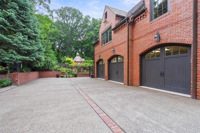 1909 Highgate Rd, Upper St Clair, PA 15241 - view of home's exterior featuring brick siding, an attached garage, asphalt driveway, and a high end roof