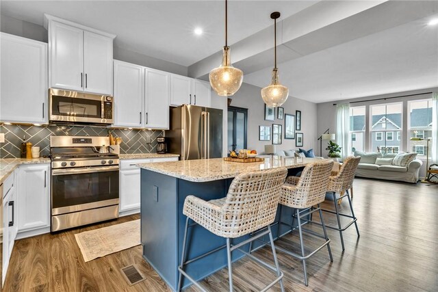 620 Amarth Ln, Cranberry Twp, PA 16066 - kitchen featuring appliances with stainless steel finishes, wood finished floors, a center island, white cabinetry, and recessed lighting