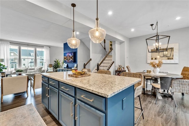 620 Amarth Ln, Cranberry Twp, PA 16066 - kitchen featuring open floor plan, dark wood-type flooring, a breakfast bar area, blue cabinets, and a kitchen island