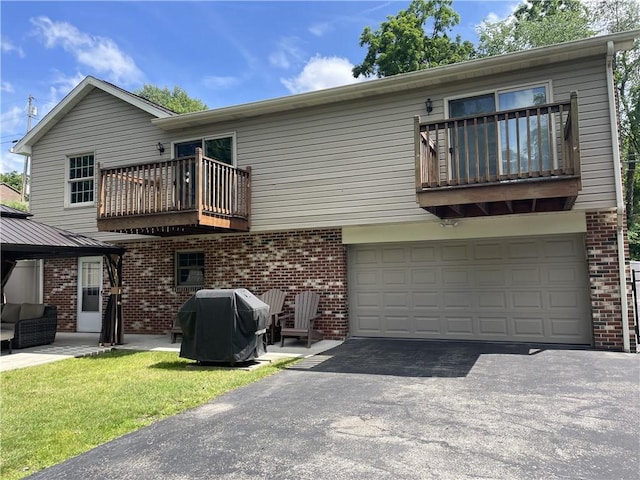 10240 Roseway Blvd, North Huntingdon, PA 15642 - rear view of property featuring a balcony, asphalt driveway, a garage, and brick siding