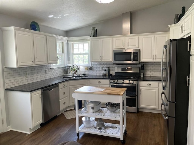 10240 Roseway Blvd, North Huntingdon, PA 15642 - kitchen with stainless steel appliances, white cabinets, dark wood finished floors, backsplash, and vaulted ceiling