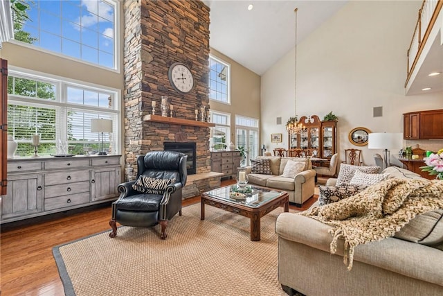 1041 Ashfield Way, Salem Twp Wml, PA 15601 - living area with high vaulted ceiling, wood finished floors, a stone fireplace, and a chandelier