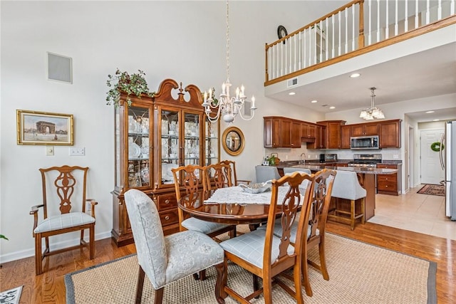 1041 Ashfield Way, Salem Twp Wml, PA 15601 - dining area with a chandelier, light wood-type flooring, a towering ceiling, and recessed lighting