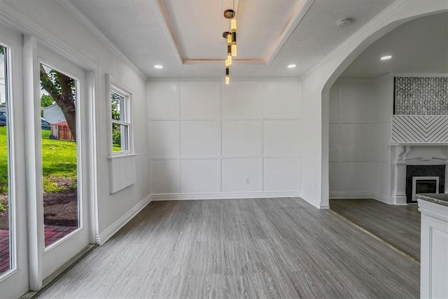 322 S Broadway St, Scottdale, PA 15683 - unfurnished dining area with a decorative wall, wood finished floors, arched walkways, a fireplace, and ornamental molding