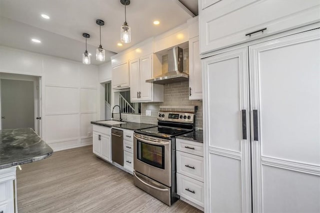 322 S Broadway St, Scottdale, PA 15683 - kitchen featuring stainless steel appliances, wall chimney exhaust hood, white cabinetry, tasteful backsplash, and light wood-type flooring