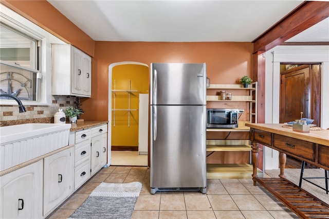 12091/2 Vance Ave, Coraopolis, PA 15108 - kitchen with stainless steel appliances, white cabinets, light tile patterned floors, and decorative backsplash