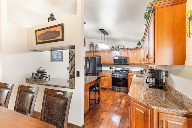 223 Horseshoe Dr, Adams Twp, PA 16046 - kitchen with stainless steel appliances, vaulted ceiling, hardwood / wood-style floors, light stone counters, and brown cabinetry