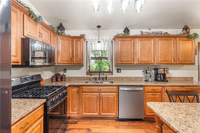 223 Horseshoe Dr, Adams Twp, PA 16046 - kitchen with stainless steel appliances, light wood-style floors, light stone counters, pendant lighting, and brown cabinetry