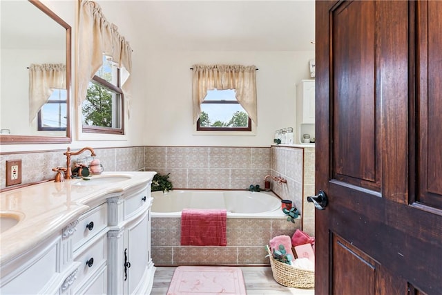 223 Horseshoe Dr, Adams Twp, PA 16046 - full bathroom featuring a bath, double vanity, and wood finished floors